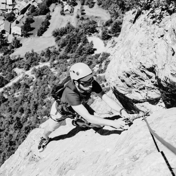 Un homme qui grimpe une paroi rocheuse.